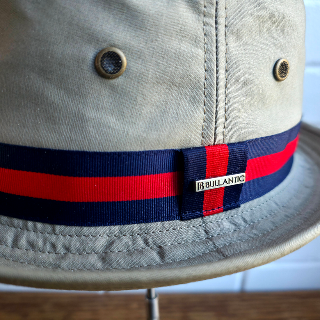 Close-up of the navy and red striped band, Bullantic bar badge and mesh air vents